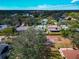 Residential area captured from above shows houses with mature landscaping, and a glimpse of a distant cityscape on a bright day at 6145 Bonaventure Ct, Sarasota, FL 34243