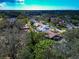 Aerial view showing residential homes with pools surrounded by lush trees in a quiet, suburban setting under a bright sky at 6145 Bonaventure Ct, Sarasota, FL 34243