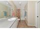 Bathroom featuring a large mirror, white vanity, and a tub-shower combo with colorful curtain at 6145 Bonaventure Ct, Sarasota, FL 34243