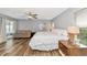 Bright bedroom with wood-look floors, ceiling fan, neutral paint and a seating area with sofa at 6145 Bonaventure Ct, Sarasota, FL 34243