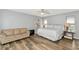 Spacious bedroom with wood-look floors, ceiling fan, neutral paint and a seating area with sofa at 6145 Bonaventure Ct, Sarasota, FL 34243