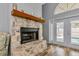 Cozy fireplace with stone hearth, mantel, and access to the outdoor pool area at 6145 Bonaventure Ct, Sarasota, FL 34243