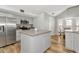 Modern kitchen with stainless steel appliances, gray cabinets, island, and an adjacent dining area at 6145 Bonaventure Ct, Sarasota, FL 34243