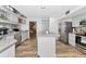 Open concept kitchen with stainless steel appliances, gray cabinetry, and wood-look flooring at 6145 Bonaventure Ct, Sarasota, FL 34243