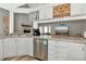 Spacious kitchen with stainless steel appliances and an open view of the living room and fireplace at 6145 Bonaventure Ct, Sarasota, FL 34243