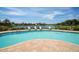 Community swimming pool with comfortable lounge chairs overlooking a peaceful lake view at 6223 Champions Row St, Bradenton, FL 34210