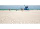 Scenic beach view featuring a lifeguard tower, clear turquoise water, and people enjoying the sunny day at 641 Verrocchio Dr, Nokomis, FL 34275