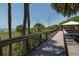 Scenic elevated boardwalk view with lush greenery, trees, and a glimpse of the ocean beyond at 641 Verrocchio Dr, Nokomis, FL 34275
