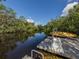 Picturesque backyard dock with a kayak overlooking a tranquil canal surrounded by lush greenery at 641 Verrocchio Dr, Nokomis, FL 34275