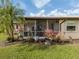 Exterior view of home and lanai, surrounded by manicured lawn and landscaping at 641 Verrocchio Dr, Nokomis, FL 34275