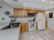 Bright kitchen featuring tile floors, light wood cabinets, and white appliances at 641 Verrocchio Dr, Nokomis, FL 34275