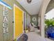 Cozy porch with a bright yellow door and charming beach-themed decor at 641 Verrocchio Dr, Nokomis, FL 34275