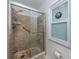 Walk-in shower featuring decorative tile and a glass door at 641 Verrocchio Dr, Nokomis, FL 34275