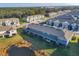 Aerial view of townhomes with green lawns and tranquil pond at 6634 Calypso Coral Ln, Sarasota, FL 34240