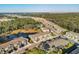 Aerial view of a residential community with a pool, pond, green spaces, and long roads at 6634 Calypso Coral Ln, Sarasota, FL 34240