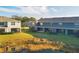 Backyard view of townhomes with green lawns and tranquil pond at 6634 Calypso Coral Ln, Sarasota, FL 34240