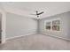 Spacious bedroom with neutral carpet, paint, and a view of mature trees at 6634 Calypso Coral Ln, Sarasota, FL 34240