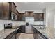 Modern kitchen featuring stainless steel appliances, dark cabinets, and marble countertops at 6634 Calypso Coral Ln, Sarasota, FL 34240