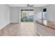 Open living room with a ceiling fan, tile flooring, and sliding glass doors to the backyard at 6634 Calypso Coral Ln, Sarasota, FL 34240