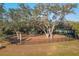 Aerial view of community playground, featuring mature trees, a slide, and fenced perimeter at 6634 Calypso Coral Ln, Sarasota, FL 34240