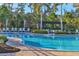 Sparkling community pool features palm trees, lounge chairs, and a pergola, perfect for relaxation and recreation at 6634 Calypso Coral Ln, Sarasota, FL 34240