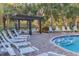 A relaxing pool area with lounge chairs, tables, and a pergola for residents to enjoy the outdoors at 6634 Calypso Coral Ln, Sarasota, FL 34240