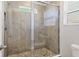 Shower featuring tiled walls and floor with glass doors and a window at 6634 Calypso Coral Ln, Sarasota, FL 34240