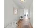 Hallway with wood floors, textured walls, bench, mirror, and views of ocean and dining area at 6701 Gulf Of Mexico Dr # 311, Longboat Key, FL 34228