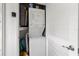 Laundry closet featuring a stacked washer and dryer, water heater, and added storage space at 6701 Gulf Of Mexico Dr # 311, Longboat Key, FL 34228