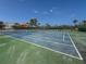 Community tennis courts surrounded by lush landscaping and blue sky at 6701 Gulf Of Mexico Dr # 311, Longboat Key, FL 34228