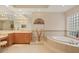 Bright bathroom featuring tile flooring, a soaking tub, vanity, and decorative elements at 6922 Stanhope Pl, University Park, FL 34201