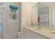 Bathroom features a vanity with decorative accents and a walk-in shower with patterned curtains at 6922 Stanhope Pl, University Park, FL 34201