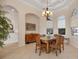 The dining room has a stylish chandelier, large windows, and ample seating at 6922 Stanhope Pl, University Park, FL 34201