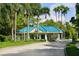 Community entrance with lush landscaping, tiled roof, and a guard house at 6922 Stanhope Pl, University Park, FL 34201