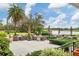 Outdoor patio area with seating, lush landscaping, and a picturesque lake view at 6922 Stanhope Pl, University Park, FL 34201
