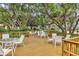 Inviting outdoor seating area on a wooden deck, shaded by mature trees at 6922 Stanhope Pl, University Park, FL 34201