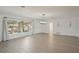 Living room with a large window to the front yard, wood-look tile floors, and modern light fixture at 730 Magellan Dr, Sarasota, FL 34243