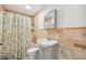 The bathroom features a shower, toilet, sink, and tan tiled walls at 7415 36Th E Ave, Palmetto, FL 34221