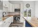 Modern kitchen with stainless steel appliances, white cabinets and a wood countertop at 7415 36Th E Ave, Palmetto, FL 34221