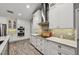 Well-lit kitchen featuring white cabinetry, stainless steel appliances, stylish backsplash, and hardwood floors at 7415 36Th E Ave, Palmetto, FL 34221