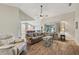 Spacious living room with wood floors, high ceilings, ceiling fan, and open view to modern kitchen at 7415 36Th E Ave, Palmetto, FL 34221