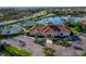 Aesthetic aerial view of a clubhouse with tennis courts, a parking lot, and well-maintained landscaping at 8284 Barton Farms Blvd, Sarasota, FL 34240