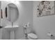Contemporary powder room featuring a pedestal sink, modern faucet, and stylish floral wall art at 8541 Coastal Palms Gln, Parrish, FL 34219