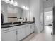 Bathroom featuring dual sinks, white cabinets, and a view into the bedroom at 8541 Coastal Palms Gln, Parrish, FL 34219