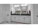 Bathroom with dual sinks, white cabinets, and shower with tile accents at 8541 Coastal Palms Gln, Parrish, FL 34219