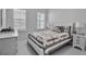 Cozy bedroom with two windows, decorative pillows, and a quilt on the bed at 8541 Coastal Palms Gln, Parrish, FL 34219