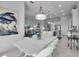 Bright dining area with white table, chairs, and modern lighting fixtures at 8541 Coastal Palms Gln, Parrish, FL 34219
