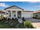 Charming single-story home with a covered porch, well-manicured landscaping, and a two-car garage at 8541 Coastal Palms Gln, Parrish, FL 34219