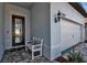 Welcoming front entrance featuring a bench, black door, and view of the two-car garage at 8541 Coastal Palms Gln, Parrish, FL 34219