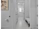 Neutral-toned hallway with white doors, tile flooring, and access to the laundry room at 8541 Coastal Palms Gln, Parrish, FL 34219